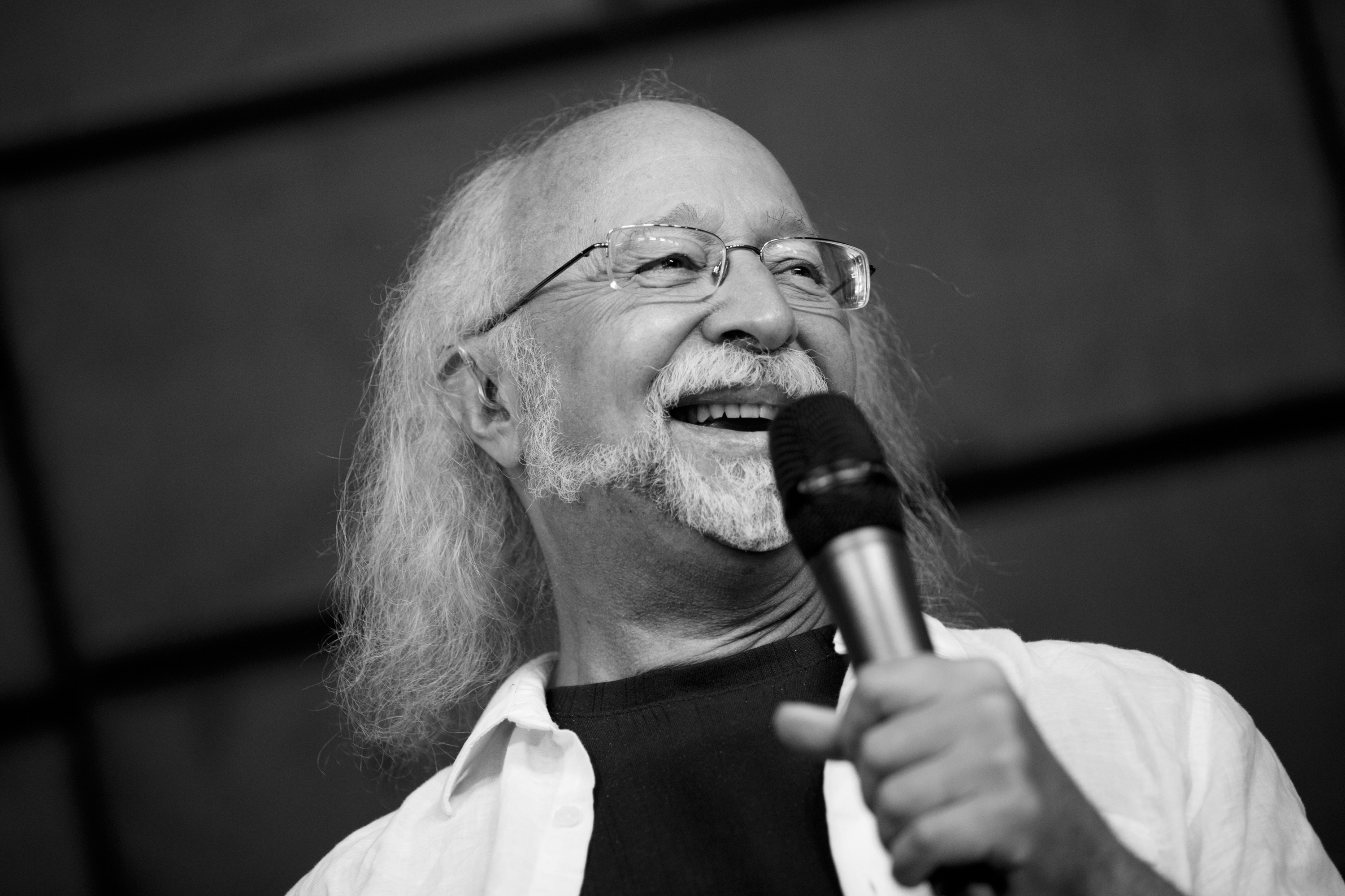 Steven Forrest smiling while holding a microphone